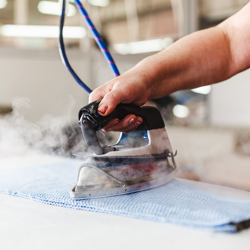 Professional,Ironing,In,Dry,Cleaner,Detail,Of,Iron,And,Hands.
